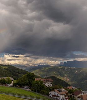Stormy clouds and a rainbow over Jenesien