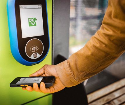 Ticket scan with smartphone at a reader, display shows “OK” confirmation.